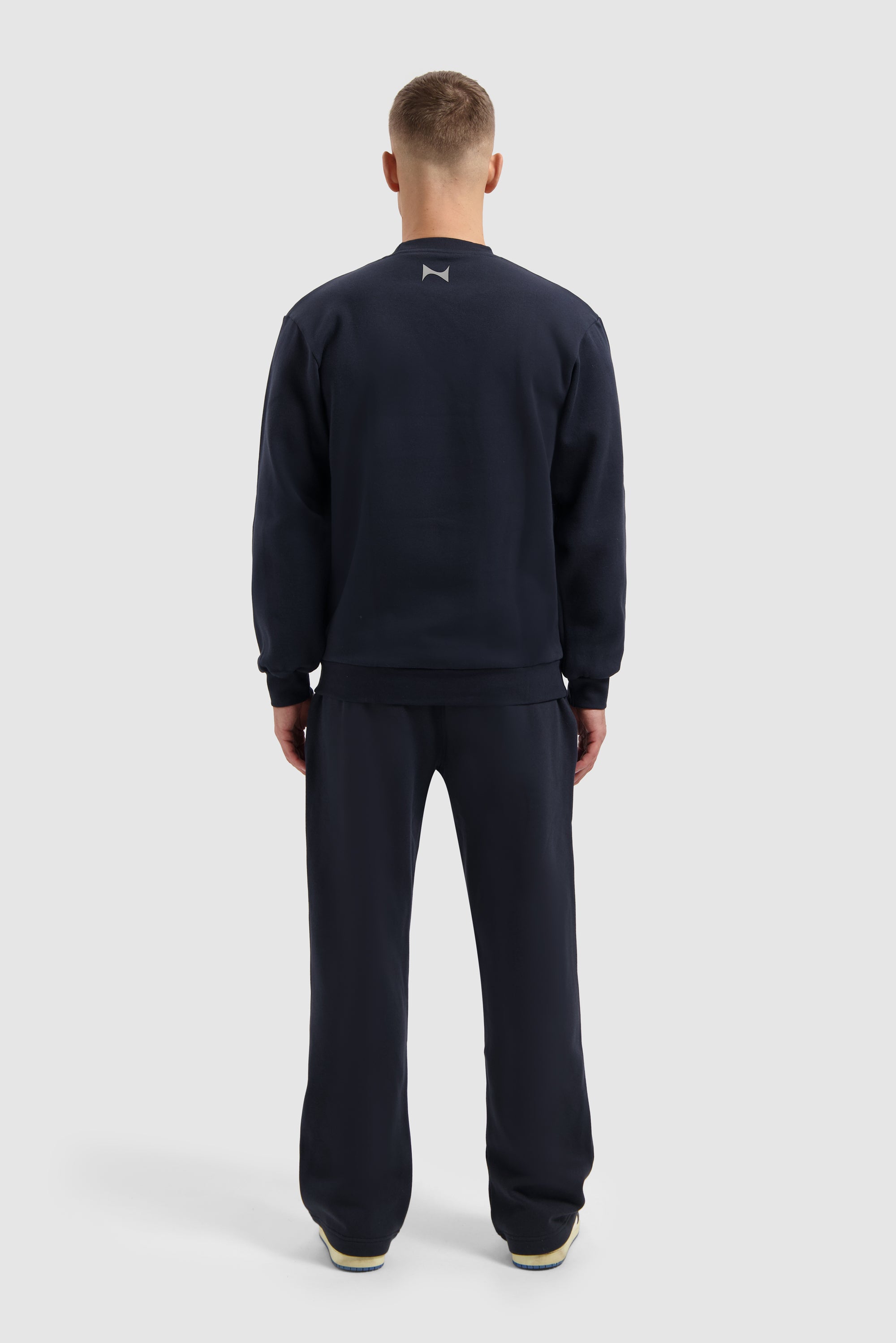 Marineblaues Fleece-Sweatshirt an einem Model, Rückansicht, gesamtes Outfit