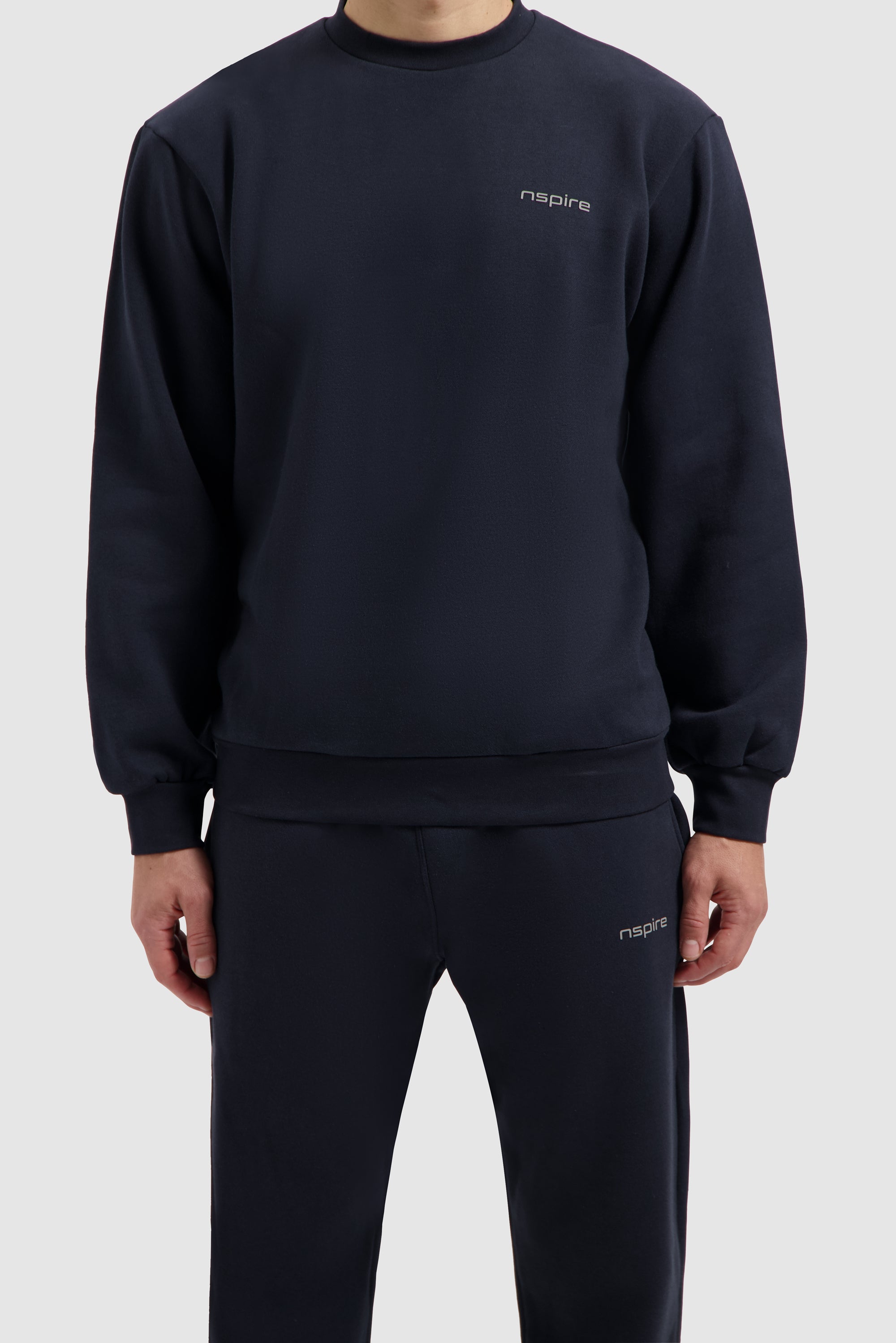 Marineblaues Fleece-Sweatshirt an einem Model, Nahaufnahme von vorn, Oberkörper und oberer Hosenbereich